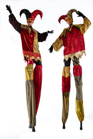 stilt walkers in red black and gold jester costumes